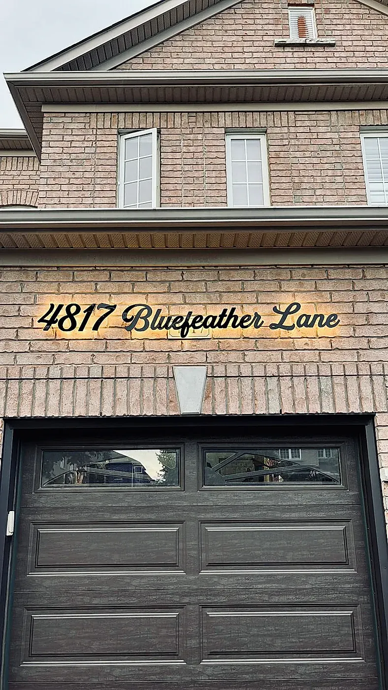4817 Bluefeather Lane in black script on a brick gable