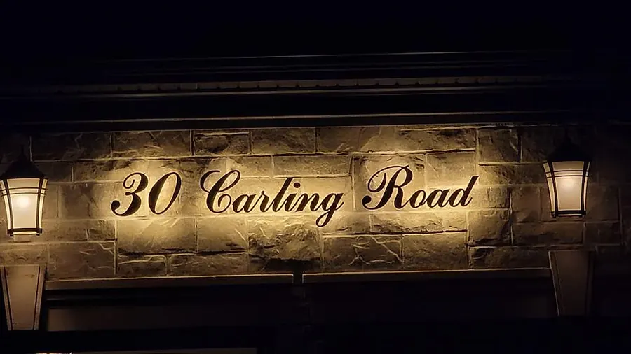30 Carling Road in gold, backlit between two lanterns