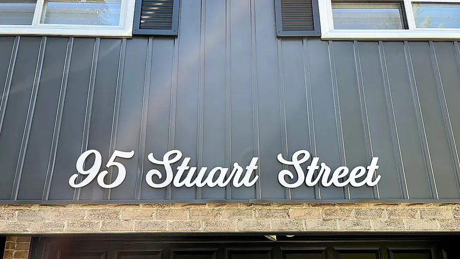95 Stuart Street in white script on grey standing-seam siding